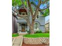 Classic two-story home featuring brick accents, a cozy porch, and a landscaped front yard with mature trees at 444 S Pearl St, Denver, CO 80209