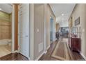 Hallway with hardwood flooring, leading past a bathroom and into the living areas at 12732 Fisher Dr, Englewood, CO 80112