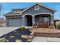 Charming home featuring an attached garage and a beautifully landscaped front yard with decorative rock and curated garden spaces at 5519 Genoa St, Denver, CO 80249