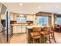 Open kitchen featuring an island with bar seating and stainless steel appliances at 6432 E Jamison Cir, Centennial, CO 80112