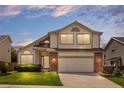 Inviting two-story home featuring brick accents, a two-car garage, and a cozy, landscaped front yard at 8985 Edgewood Ln, Highlands Ranch, CO 80130
