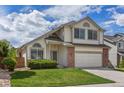 Inviting two-story home featuring a well-kept lawn, charming windows and a two-car garage at 8985 Edgewood Ln, Highlands Ranch, CO 80130