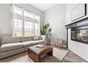 Cozy living room with fireplace, large windows, neutral tones, and lots of natural light at 3502 Nez Perce Trl, Castle Rock, CO 80109