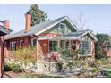 Beautiful brick home featuring a cozy porch and lush landscaping at 479 S Clarkson St, Denver, CO 80209
