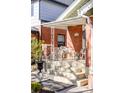 Inviting front porch with seating, a decorative railing, and a brick facade at 479 S Clarkson St, Denver, CO 80209