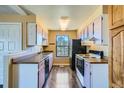 Cozy kitchen with warm lighting, practical layout, and a view of a large window at 11922 Bellaire St # F, Thornton, CO 80233