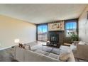 Inviting living room with fireplace, large windows, and sliding glass doors to a private balcony at 11922 Bellaire St # F, Thornton, CO 80233