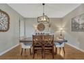 Elegant dining room with hardwood floors, stylish lighting fixture, and ample seating at 26566 E Peakview Dr, Aurora, CO 80016
