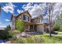 Charming front exterior featuring a covered porch, lush landscaping, and a well-maintained lawn at 26566 E Peakview Dr, Aurora, CO 80016