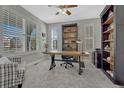 Well-lit office with large windows, built-in bookshelves, and a spacious work area at 26566 E Peakview Dr, Aurora, CO 80016