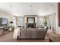 Cozy living room with a fireplace, comfortable seating, and large windows for natural light and access to the balcony at 4913 Cathay Ct, Denver, CO 80249