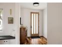 Inviting entryway with hardwood floors, a stylish console, and a frosted glass front door at 3130 Wyandot St, Denver, CO 80211