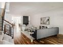 Open-concept living room with hardwood floors, a modern fireplace, and staircase with metal railings at 3130 Wyandot St, Denver, CO 80211