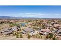 Picturesque aerial view featuring the neighborhood's pond, greenery and stunning mountain views at 10704 Flowerburst Ct, Highlands Ranch, CO 80126