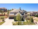 Expansive home showcasing a stone facade, a three-car garage, and professionally landscaped front yard at 10704 Flowerburst Ct, Highlands Ranch, CO 80126