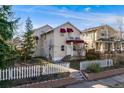 Charming home with a white picket fence, lush trees, and a cozy balcony; perfect for enjoying the outdoors at 2047 S Franklin St, Denver, CO 80210