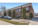 Brick exterior of Avenue Lofts with balconies, mature landscaping, and parking area at 1000 E 18Th Ave # 107, Denver, CO 80218
