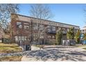 Avenue Lofts exterior showing brick facade, balconies, and landscaped entrance on a sunny day at 1000 E 18Th Ave # 107, Denver, CO 80218