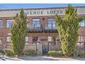 Avenue Lofts building exterior with brick facade, balconies, and mature landscaping at 1000 E 18Th Ave # 107, Denver, CO 80218