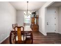 Traditional dining room featuring hardwood floors and an elegant chandelier, creating a warm atmosphere at 42425 Forest Oaks Dr, Elizabeth, CO 80107