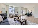 Spacious living area with a fireplace, hardwood floors, comfortable seating, and access to an outdoor patio at 2120 W 31St Ave, Denver, CO 80211