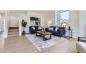 Open living area with hardwood floors, stylish sofas, and a large area rug creating a comfortable and modern living space at 2120 W 31St Ave, Denver, CO 80211