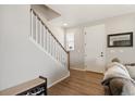 Inviting entryway with wood floors, staircase, and a stylish bench for added convenience at 8811 Meade St, Westminster, CO 80031