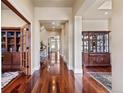 Elegant hallway with gleaming hardwood floors, recessed lighting, and decorative columns leading to other rooms at 2486 S Monroe St, Denver, CO 80210