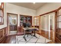 Spacious home office with hardwood floors, built-in shelving, and access to an adjacent bathroom at 2486 S Monroe St, Denver, CO 80210