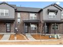 Contemporary townhome featuring a brick facade, covered porch, and modern door design at 763 N Tibet St, Aurora, CO 80018