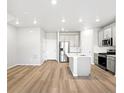 Open-concept kitchen with stainless steel appliances and center island at 763 N Tibet St, Aurora, CO 80018