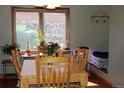 The dining area features a wooden table, four chairs, and a large window overlooking the backyard at 155 Xenon St # 33, Denver, CO 80228