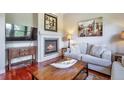 Cozy living room with a fireplace, hardwood floors, and comfortable sofa seating, perfect for relaxing at 10152 Inverness Main St, Englewood, CO 80112