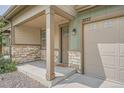 Inviting covered front porch with stone accents, a cozy entrance, and a convenient garage at 3573 S Lisbon Ct, Aurora, CO 80013