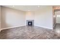 Open-concept living room features sleek gray wood floors and a modern corner fireplace at 3573 S Lisbon Ct, Aurora, CO 80013