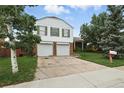 Charming two-story home featuring a two-car garage, brick accents, and mature landscaping at 2527 S Ouray Way, Aurora, CO 80013