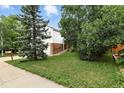 Charming home showcasing mature trees and a well-maintained lawn at 2527 S Ouray Way, Aurora, CO 80013
