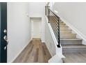 Modern entryway with gray vinyl plank flooring and a metal railing staircase at 8570 Eagle River St, Littleton, CO 80125