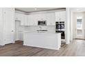 Modern white kitchen with stainless steel appliances and an island at 8570 Eagle River St, Littleton, CO 80125