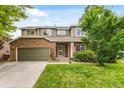 Charming two-story home with brick and siding, well-maintained lawn, and an attached two-car garage at 10284 Royal Eagle St, Highlands Ranch, CO 80129