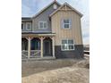 Two-story home with a mix of board siding, brick accents, and a welcoming front porch at 15218 Detroit St, Thornton, CO 80602