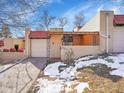 Neat brick ranch home with attached garage and snow-covered yard at 2665 S Sheridan Ct, Lakewood, CO 80227