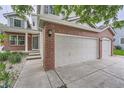 Home with a brick facade, featuring a spacious garage with white doors and concrete driveway at 6526 S Killarney Ct, Aurora, CO 80016
