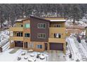 A modern exterior showing a well landscaped front yard and a driveway leading up to the two car garage at 726 Dreamcatcher Ln, Evergreen, CO 80439