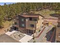 A modern townhouse features an attached garage, balconies, and thoughtful xeriscaping in a forested setting at 726 Dreamcatcher Ln, Evergreen, CO 80439