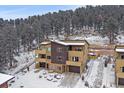 Modern townhouse featuring multi-tone exteriors, private balconies, and attached garages nestled against a snowy wooded backdrop at 726 Dreamcatcher Ln, Evergreen, CO 80439