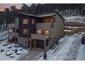 Modern townhouse featuring multi-tone exteriors, private balconies, and attached garages nestled against a snowy wooded backdrop at 726 Dreamcatcher Ln, Evergreen, CO 80439