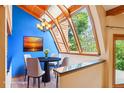 Bright dining room featuring large windows with wood trim, a modern chandelier, and sleek hardwood floors at 108 Ward Ct, Lakewood, CO 80228
