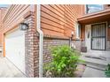 Home front entrance featuring mature landscaping, a brick trim, and a black wrought iron security door at 108 Ward Ct, Lakewood, CO 80228