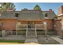 Front view of a brick building with wood shake roof and balcony at 5401 E Warren Ave # 204, Denver, CO 80222